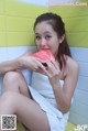 A woman sitting on a bench eating a slice of watermelon.