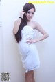 A woman in a white towel posing for a picture.