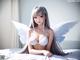 Anime girl with white wings sitting on a bed.