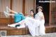 A couple of women sitting on top of a wooden bench.