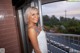 A woman in a white dress standing on a balcony.