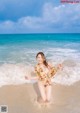 A woman in a bikini running on the beach.