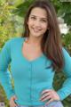 A young woman in a blue cardigan posing for a picture.