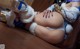 A woman in a white and blue outfit laying on a wooden floor.