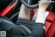 A woman sitting in a car with her legs crossed.